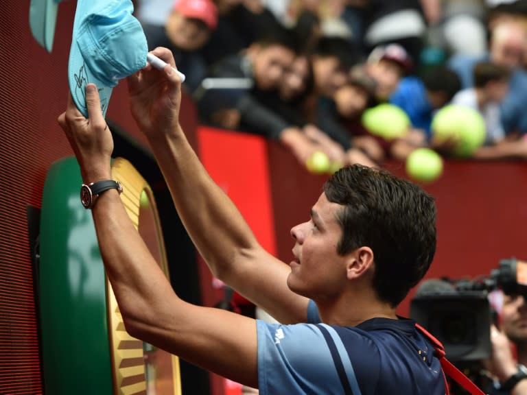 Canada's Milos Raonic signs autographs for fans following his Australian Open men's singles fourth round victory against Switzerland's Stanislas Wawrinka, in Melbourne, on January 25, 2016