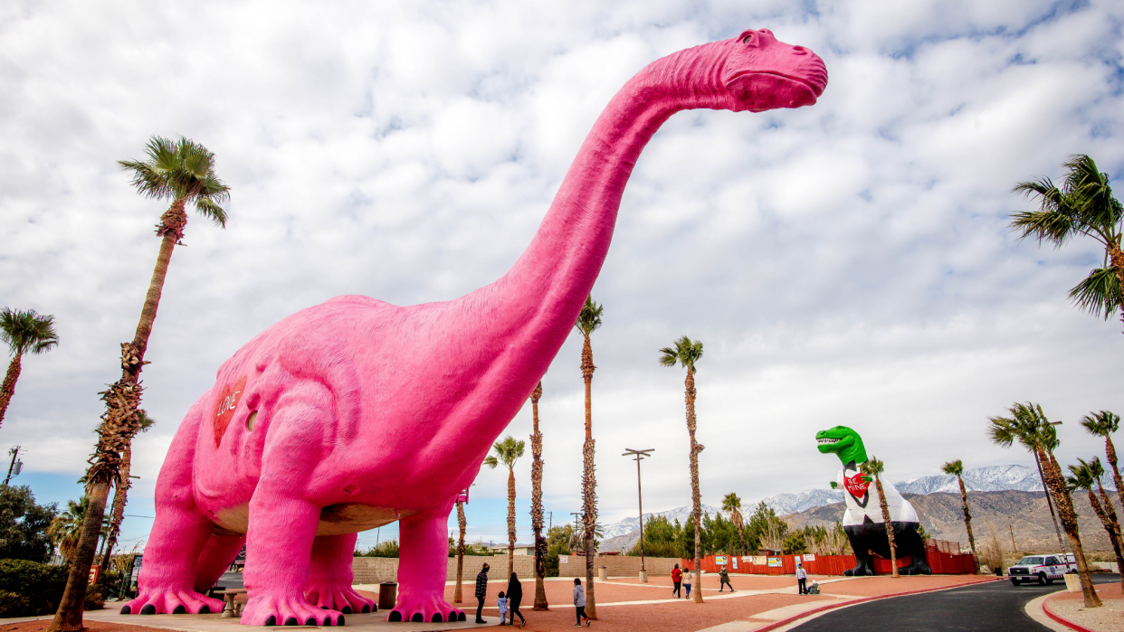  A pink dinosaur and a T-Rex dinosaur at the Cabazon Dinosaurs exhibit in Cabazon, California. 