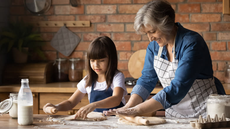 A woman and a girl roll out dough