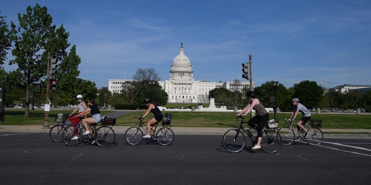 Cyclists ride past the US Capitol in Washington, DC, on April 27, 2021.