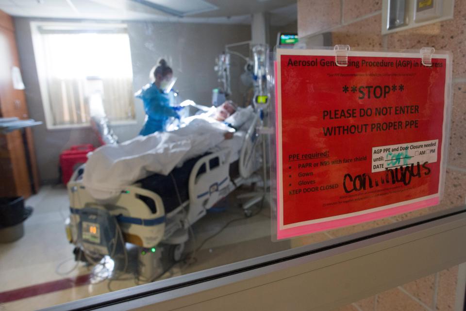 A COVID-19 patient on a ventilator is checked by Megan Lee, a resident nurse at Stormont Vail Health, inside the COVID-19 intensive care unit at the hospital in Topeka, Kansas, on Jan. 7.