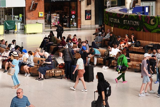 Passengers sitting and walking through a train station