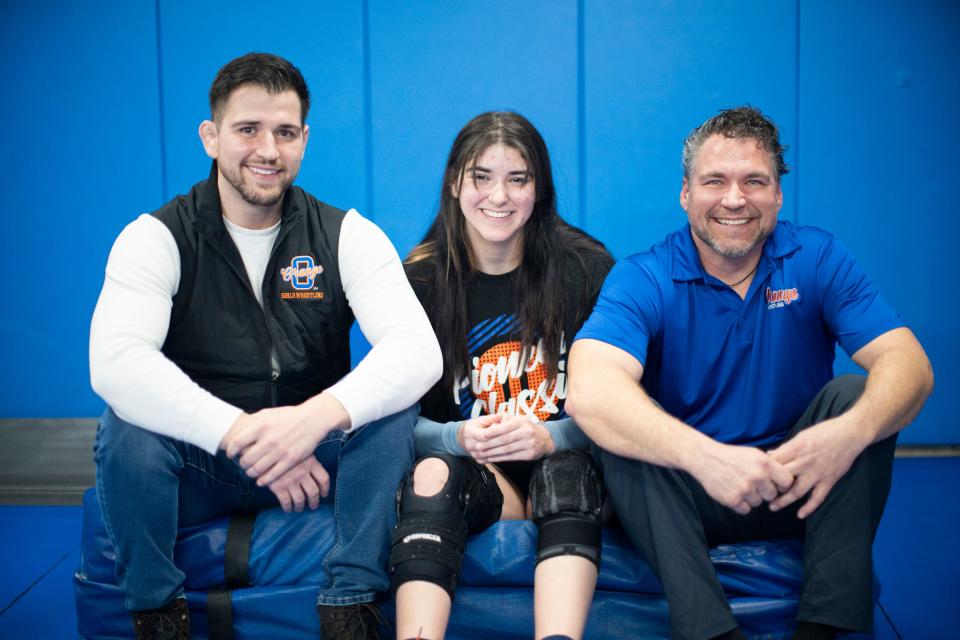 Olentangy Orange senior wrestler Kascidy Garren competes for a coaching staff that includes her brother, Patrik, left, and father Jack. Patrik won a state championship for Ready.