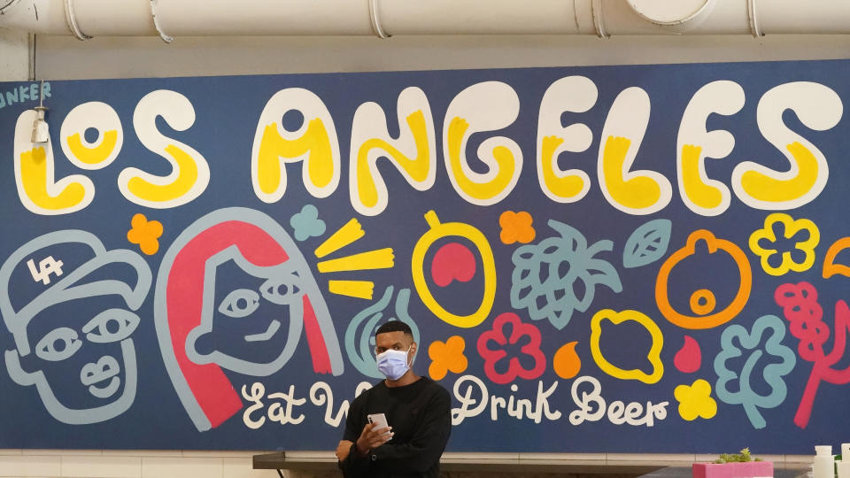 A patron wears a mask while waiting for a food order at Grand Central Market Wednesday, July 13, 2022, in Los Angeles. Los Angeles County might be imposing a mandate on July 29 if COVID-19 numbers continue to rise. (AP Photo/Marcio Jose Sanchez)