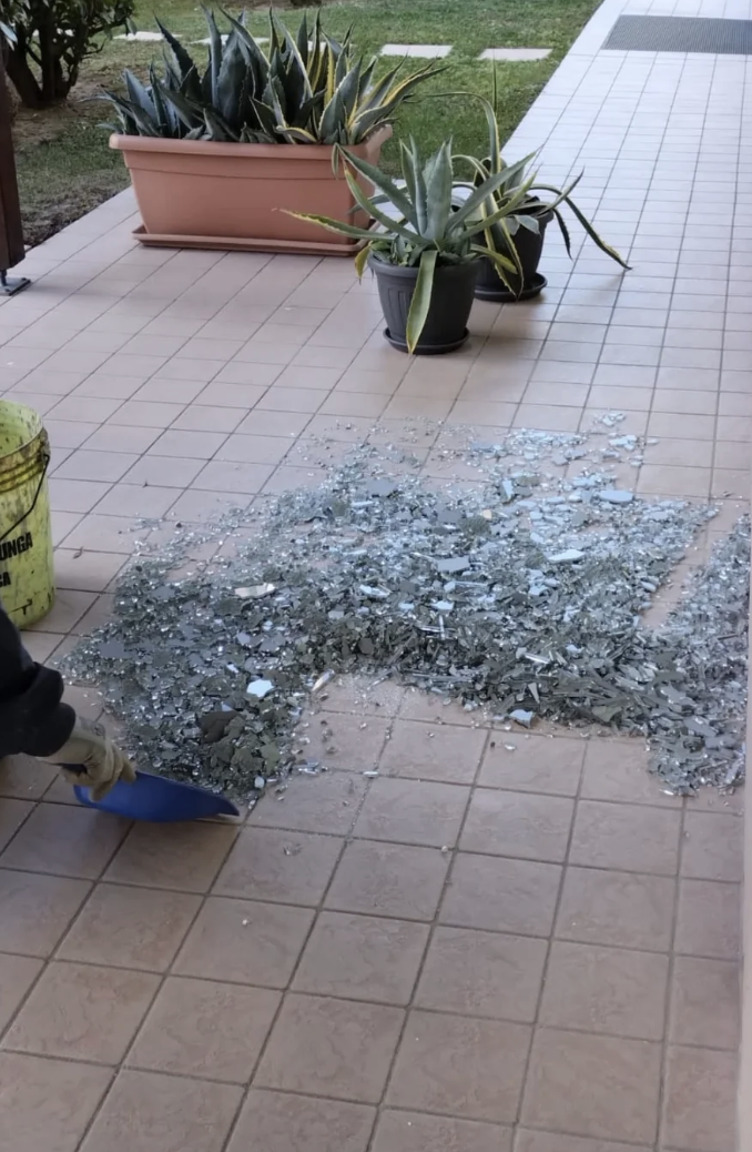Broken glass shards on a tiled outdoor area