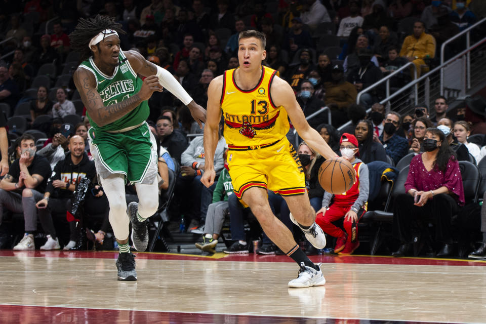 Atlanta Hawks guard Bogdan Bogdanovic (13) drives past Boston Celtics center Robert Williams III (44) during the second half of an NBA basketball game Friday, Jan. 28, 2022, in Atlanta. (AP Photo/Hakim Wright Sr.)