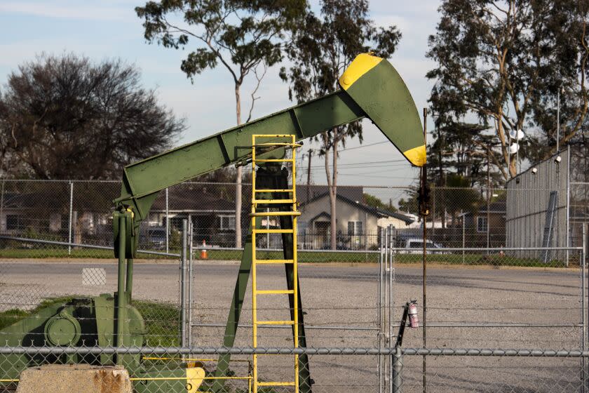 Los Angeles, CA - January 26: Home are seen behind an Oil derrick pump inside the Wilmington Athletic Complex, in the Wilmington neighborhood of Los Angeles, CA, Wednesday, Jan. 26, 2022. The Los Angeles City Council voted Wednesday to ban new oil and gas wells and to phase out existing wells over a five-year period.(Jay L. Clendenin / Los Angeles Times)