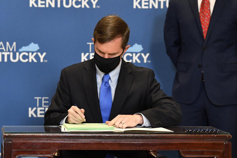 Kentucky Governor Andy Beshear signs a bill related to the American Rescue Plan Act in the Rotunda of the Kentucky State Capitol in Frankfort, Ky., Wednesday, April 7, 2021. (AP Photo/Timothy D. Easley)