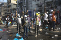 Protesters wearing safety helmets shout slogans and flash three-finger salutes during an anti-coup protest behind a barrier on a blocked road in Yangon, Myanmar, Tuesday, March 2, 2021. Demonstrators in Myanmar took to the streets again on Tuesday to protest last month’s seizure of power by the military, as foreign ministers from Southeast Asian countries prepared to meet to discuss the political crisis. Police in Yangon, Myanmar's biggest city, used tear gas against the protesters. (AP Photo)