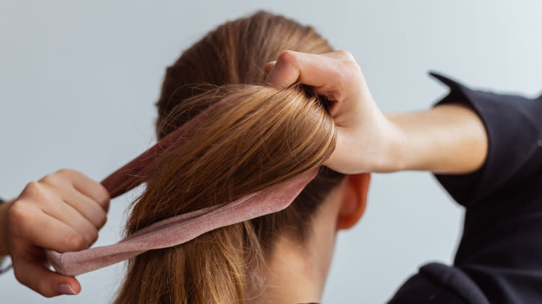 Woman putting hair in ponytail