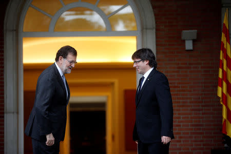 Spanish acting Prime Minister Mariano Rajoy (L) and Catalan President Carles Puigdemont react after posing for the media at the Moncloa Palace in Madrid, Spain, April 20, 2016. REUTERS/Susana Vera