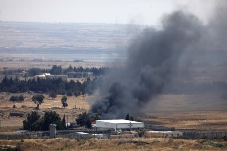 Black smoke is seen near the Israeli part of the Quneitra crossing at the Syrian side of the Israeli Syrian border as it is seen from the Israeli-occupied Golan Heights, Israel July 22, 2018. REUTERS/Ronen Zvulun