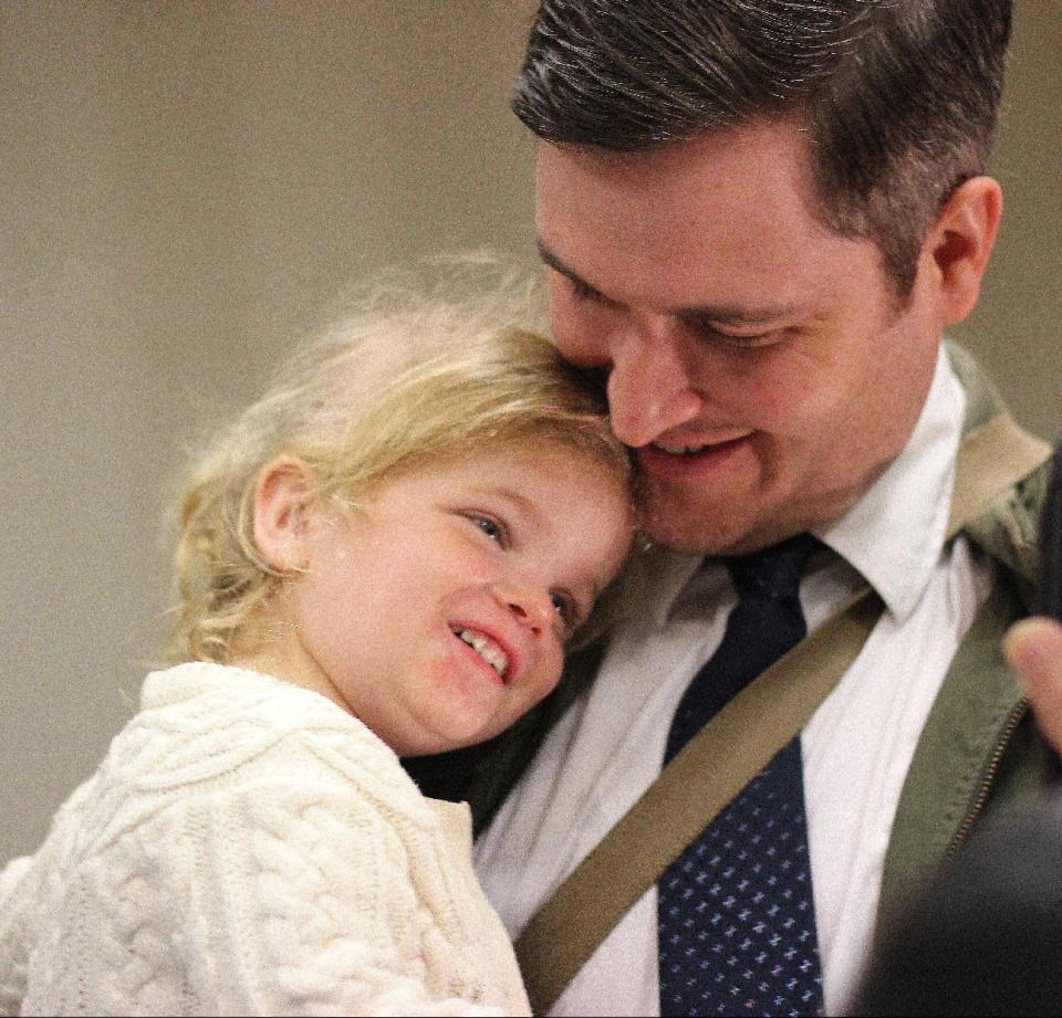 Nicholas J. Van Sickels stands with his husband, Andrew S. Bond, not seen, and holds their adopted daughter, Jules, 2, before a news conference in New Orleans about a federal lawsuit filed Wednesday, Feb. 12, 2014, to challenge the Louisiana Constitution’s ban on recognizing same-sex marriages performed in states where they are legal. They are among four couples, all married states where same-sex marriage is legal, who joined the Forum for Equality Louisiana in a suit against the state registrar and state revenue secretary. (AP Photo/Janet McConnaughey)