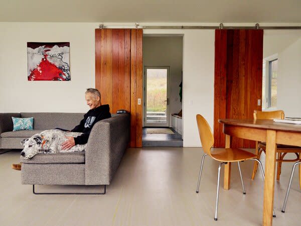 Wood salvaged from the remnants of a silo taken down by the previous owner was used to frame the kitchen cabinets and make sliding doors. The Bonnie and Clyde sectional is from Blu Dot.