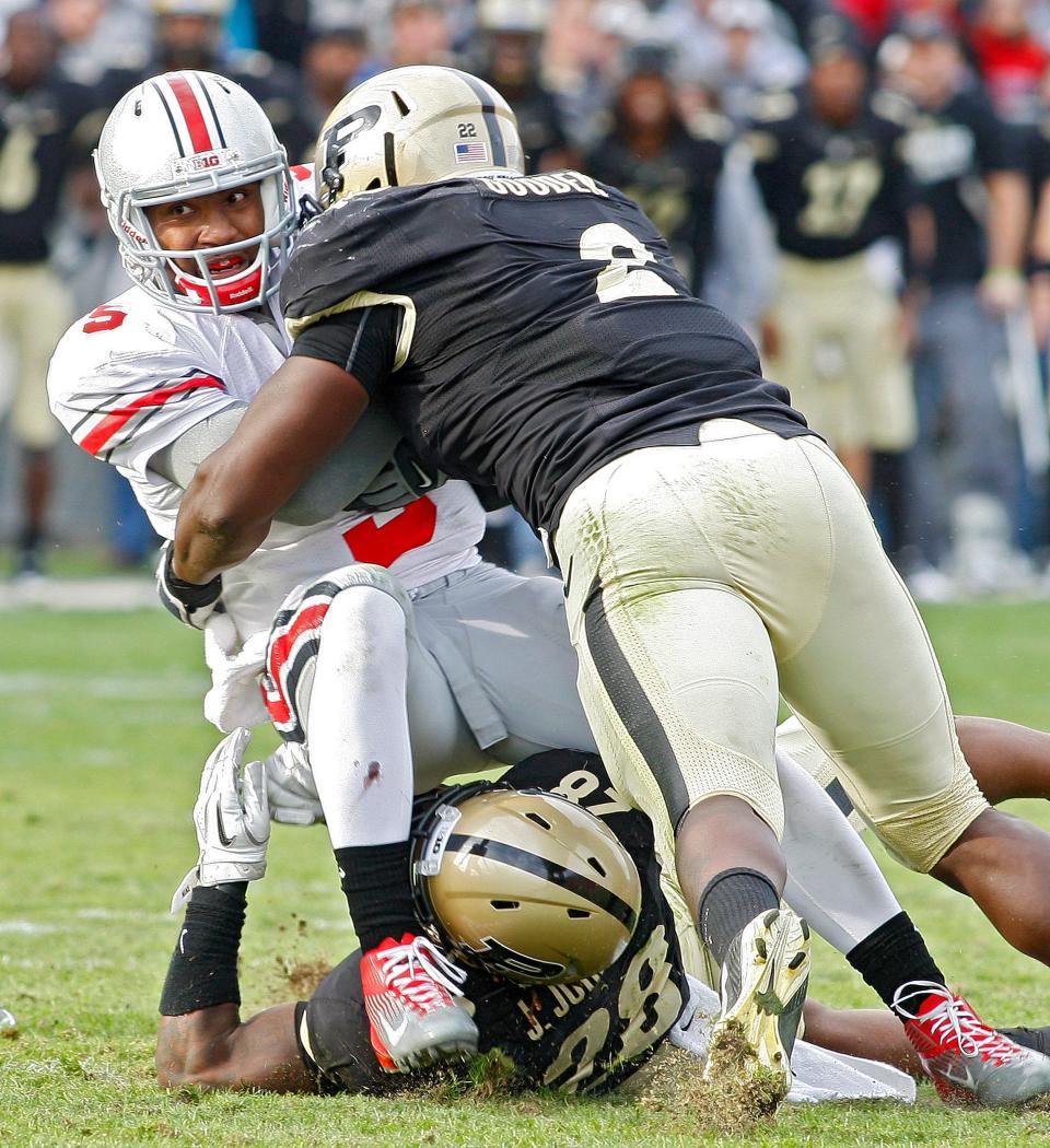 Ohio State Buckeyes quarterback Braxton Miller (5) is sacked by Purdue Boilermakers cornerback Josh Johnson (28) and Purdue Boilermakers defensive end Gerald Gooden (2) in the fourth quarter of their NCAA football game at Ross-Ade Stadium in West Lafayette, Indiana November 11, 2011. (Dispatch photo by Kyle Robertson)