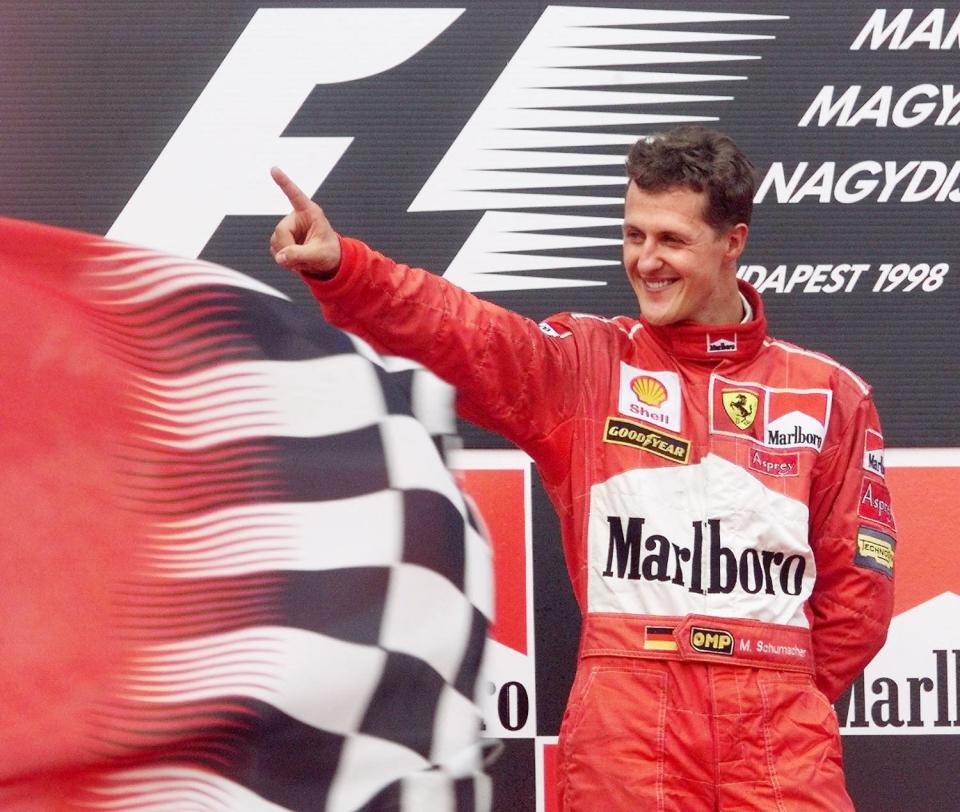 Michael Schumacher celebrates on the podium after winning the Hungarian Grand Prix on 16 August on the Hungaroring racetrack in Budapest. (ELECTRONIC IMAGE) (Photo by ERIC CABANIS / AFP) (Photo by ERIC CABANIS/AFP via Getty Images)