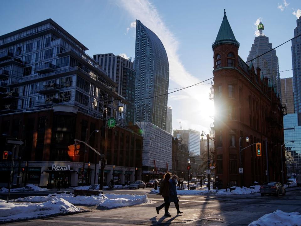 People walk past Toronto’s Flatiron building during an extreme cold warning on Jan. 28, 2022. Environment Canada has issued a warning for Thursday night into Friday morning. (Evan Mitsui/CBC - image credit)