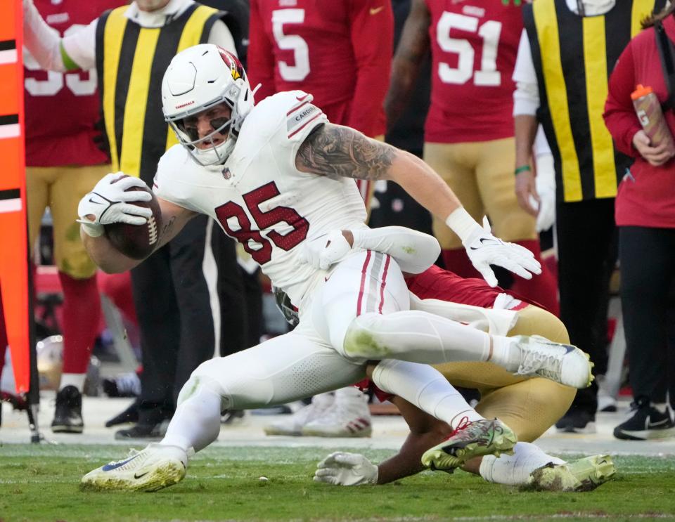 Arizona Cardinals tight end Trey McBride (85) is tackled by San Francisco 49ers cornerback Deommodore Lenoir (2) during the third quarter at State Farm Stadium on Dec. 17, 2023.