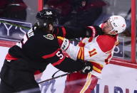 Ottawa Senators defenseman Mike Reilly (5) gives Calgary Flames center Mikael Backlund (11) a shove during second period NHL hockey action in Ottawa on Monday, March 1, 2021. (Sean Kilpatrick/The Canadian Press via AP)