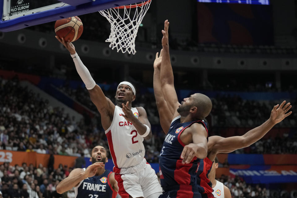 El escolta de Canadá Shai Gilgeous-Alexander (2) dispara sobre la defensa del alero de Francia Nicolas Batum (5) durante el partido por el Grupo H del Mundial entre Francia y Canadá, el viernes 25 de agosto de 2023, en Yakarta. (AP Foto/Dita Alangkara)