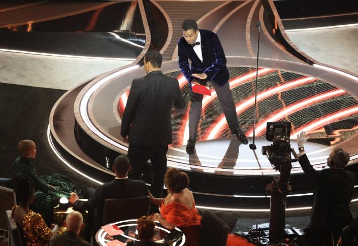 Denzel Washington talks to Chris Rock onstage during the show at the 94th Academy Awards.