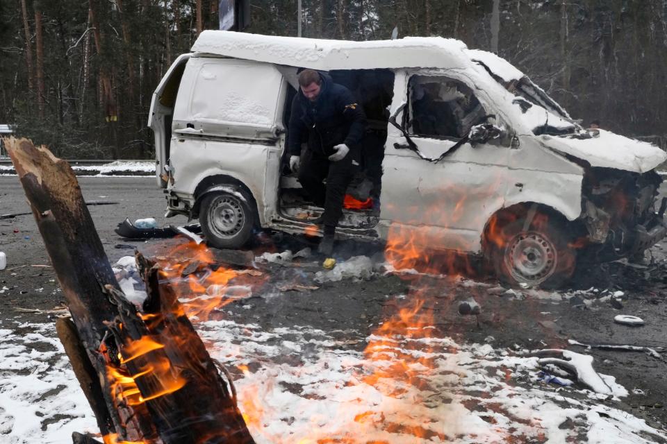 A man leaves a vehicle damaged by shelling in Brovary, outside Kyiv, Ukraine, on Tuesday.