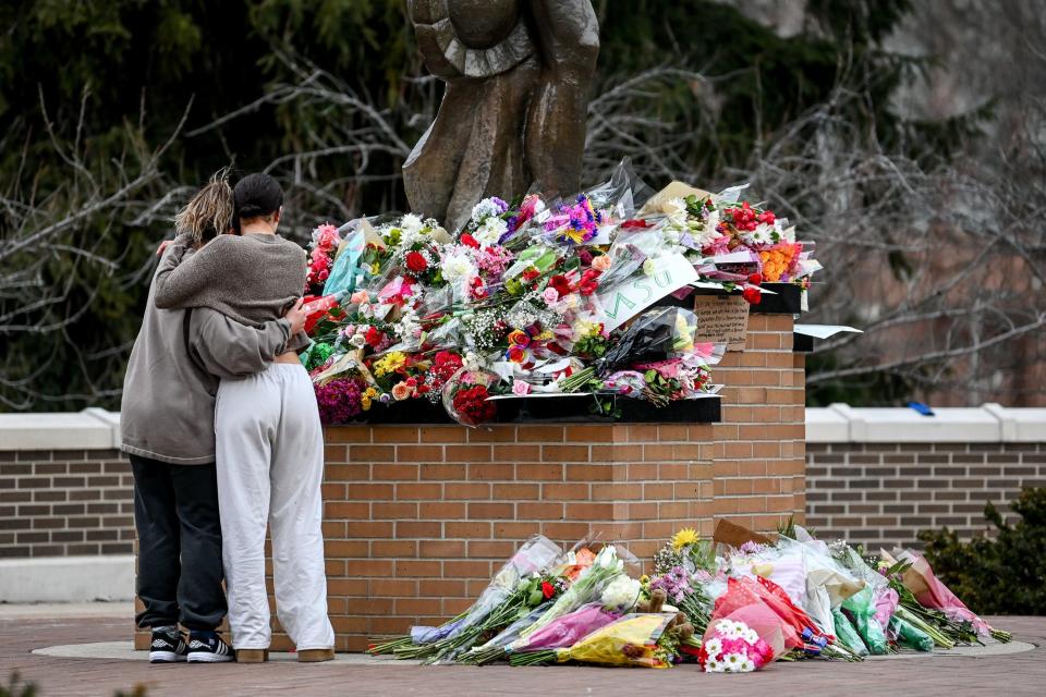 Michigan State University juniors Morgan Wright, left, and Ava Van Vleck embrace as they reflect at the Sparty statue on Tuesday, Feb. 14, 2023, on the MSU campus in East Lansing a day after a shooting at the university.
