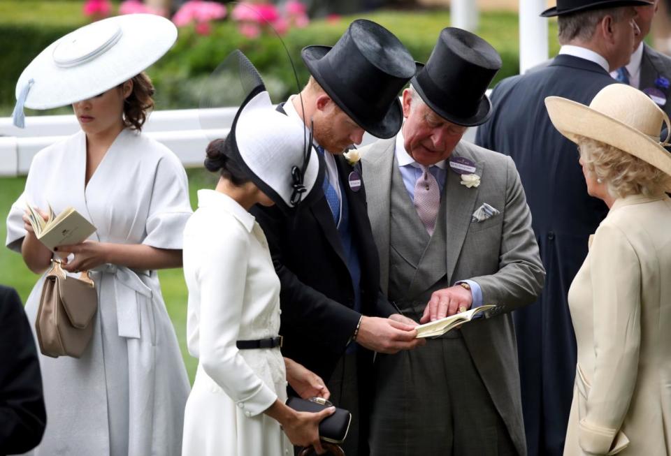 The Prince of Wales and the Duke and Duchess of Sussex consult the race card, as the Duchess of Cornwall watches on (PA)