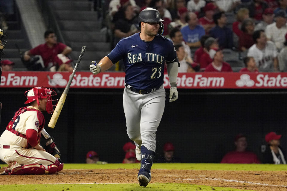 Seattle Mariners' Ty France, right, drops his bat as he hits a two-run home run while Los Angeles Angels catcher Max Stassi kneels at the plate during the seventh inning of a baseball game Friday, Sept. 16, 2022, in Anaheim, Calif. (AP Photo/Mark J. Terrill)
