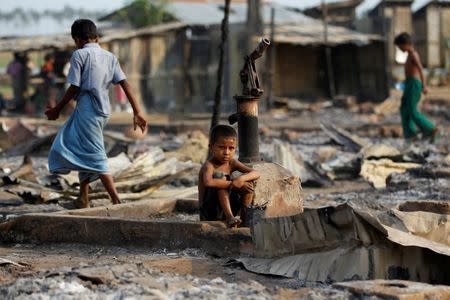 A boy sit in a burnt area after fire destroyed shelters at a camp for internally displaced Rohingya Muslims in the western Rakhine State near Sittwe, Myanmar May 3, 2016. REUTERS/Soe Zeya Tun/Files