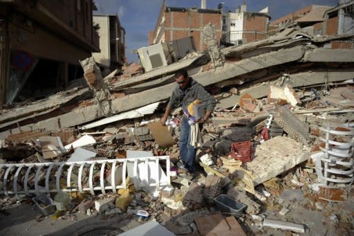 A man collects his belongings from a destroyed house in Lorca, southern Spain. Spain mourned on Friday the nine people killed after a 5.1-magnitude earthquake struck the historic southern city, forcing thousands to flee their homes