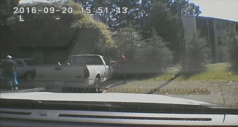 This police dash camera image shows Keith Lamont Scott (L) getting out of a car as officers look on with guns drawn in Charlotte, North Carolina on September 20, 2016