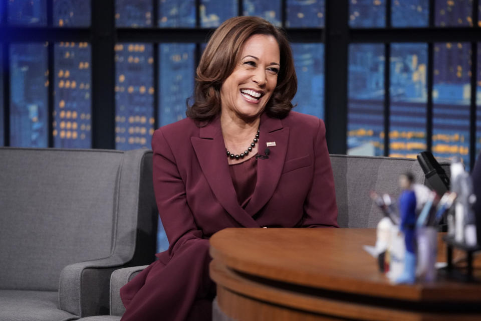 Vice President Kamala Harris seated, smiling during an interview on a late-night talk show