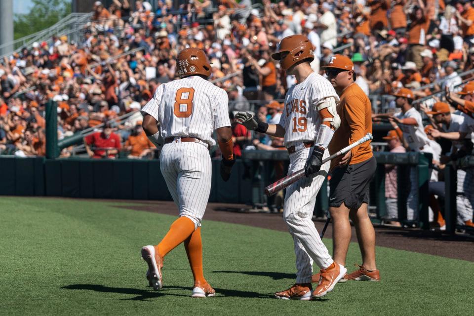 Dylan Campbell, left, high-fives Mitchell Daly after scoring a run during a game at UFCU Disch-Falk Field against Texas Tech on March 25. Campbell's 26-game hitting streak started against the Red Raiders.