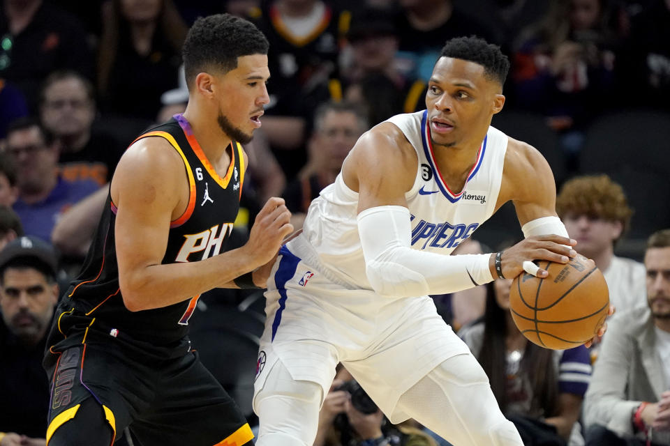 Los Angeles Clippers guard Russell Westbrook backs down Phoenix Suns guard Devin Booker during the second half of Game 1 of their first-round NBA playoff series on April 16, 2023, at Footprint Center in Phoenix. (AP Photo/Matt York)