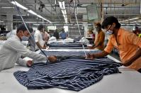 Garment workers cut fabric to make shirts at a textile factory of Texport Industries in Hindupur