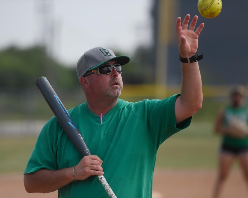 Coach Kevin Hermes catching a softball during practice, Tuesday, May 21, 2019, in Banquete. Hermes is an assistant coach for the team. 