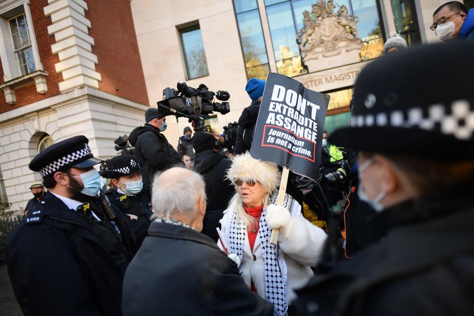 Police speak to a supporter of Wikileaks founder Julian Assange outside Westminster Magistrates court in London as he appears for a bail hearing on January 6, 2021. (Photo by JUSTIN TALLIS / AFP) (Photo by JUSTIN TALLIS/AFP via Getty Images)