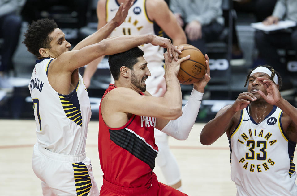 Portland Trail Blazers center Enes Kanter, center, is fouled by Indiana Pacers guard Malcolm Brogdon, left, during the second half of an NBA basketball game in Portland, Ore., Thursday, Jan. 14, 2021. (AP Photo/Craig Mitchelldyer)