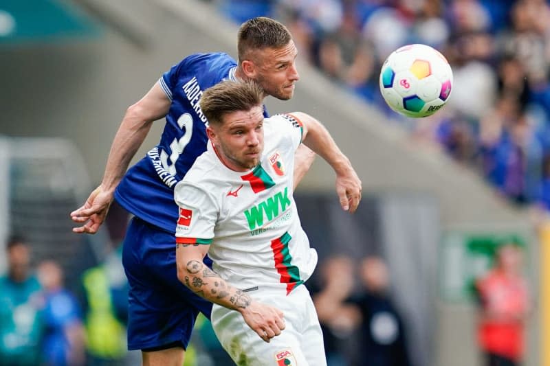 Hoffenheim's Pavel Kaderabek (L) and Augsburg's Mads Pedersen battle for the ball during the German Bundesliga soccer match between TSG 1899 Hoffenheim and FC Augsburg at the PreZero Arena. Uwe Anspach/dpa