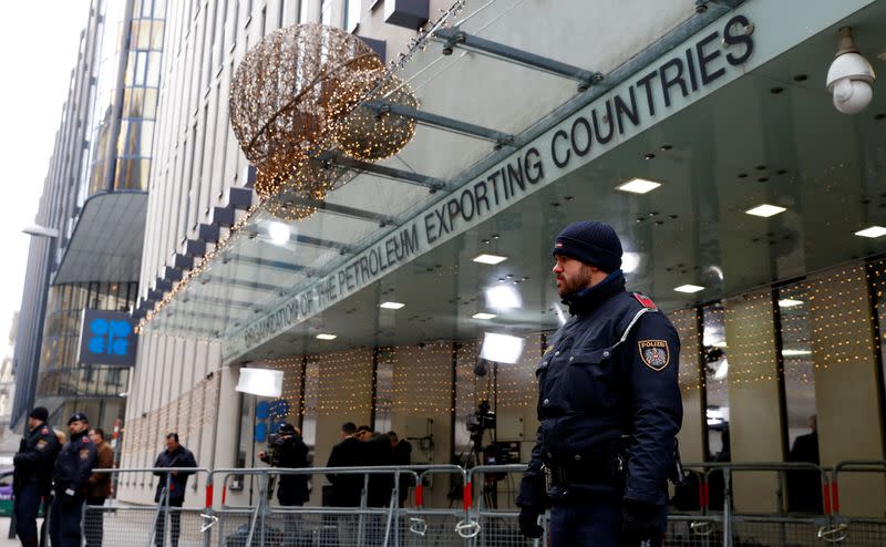 Journalists and police officers stand outside the Organisation of the Petroleum Exporting Countries (OPEC) headquarters in Vienna