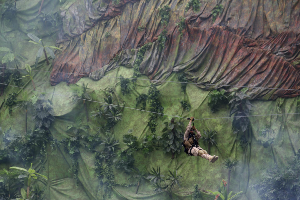 A soldier travels down a zip line during a military demonstration at the International Defense Exhibition and Conference in Abu Dhabi, United Arab Emirates, Sunday, Feb. 17, 2019. The biennial arms show in Abu Dhabi comes as the United Arab Emirates faces increasing criticism for its role in the yearlong war in Yemen. (AP Photo/Jon Gambrell)