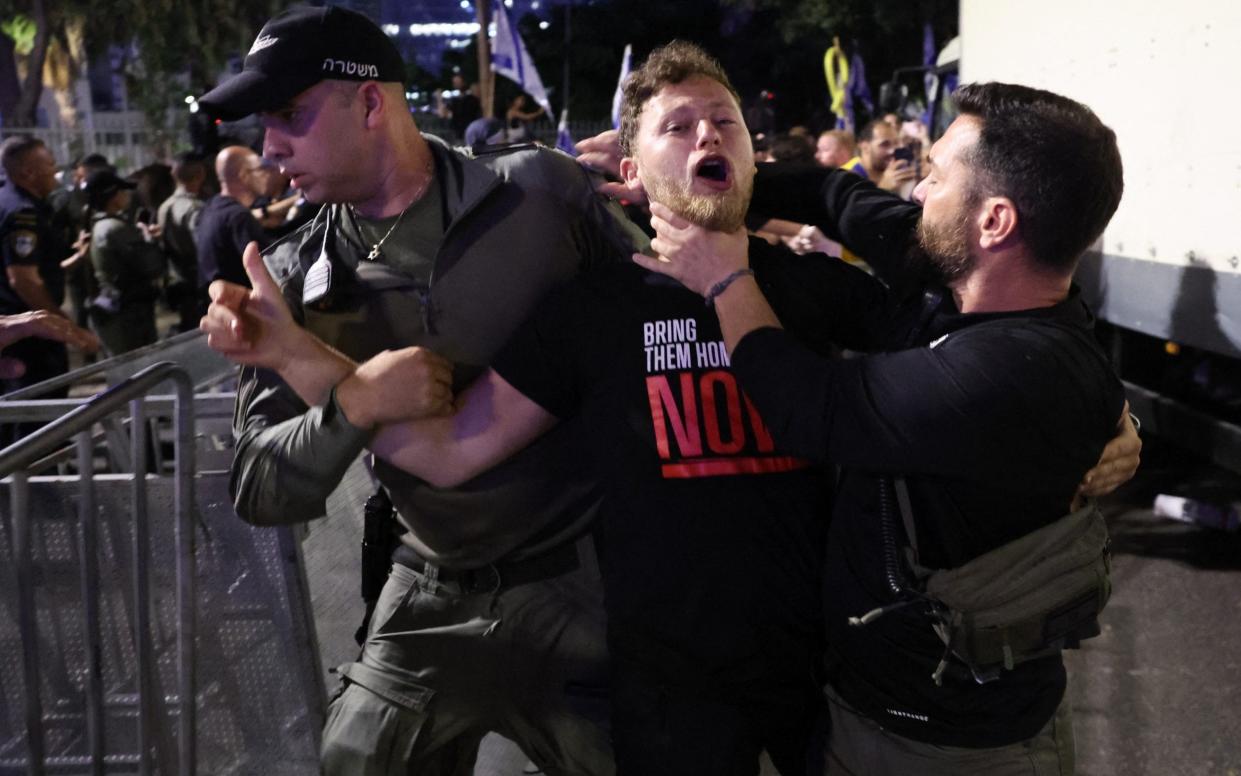 Israeli Police officers detain a protester