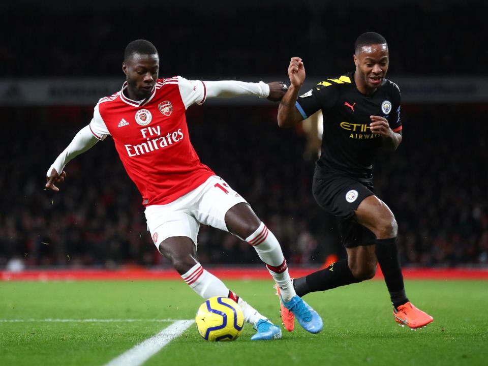 Nicolas Pepe of Arsenal is challenged by Raheem Sterling of Manchester City: Getty Images