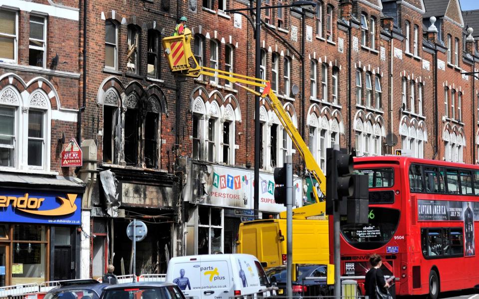  Workers look at a burnt out house after riots in Clapham, London, Great Britain, 10 August 2011 - Credit: EPA/MARIUS BECKER