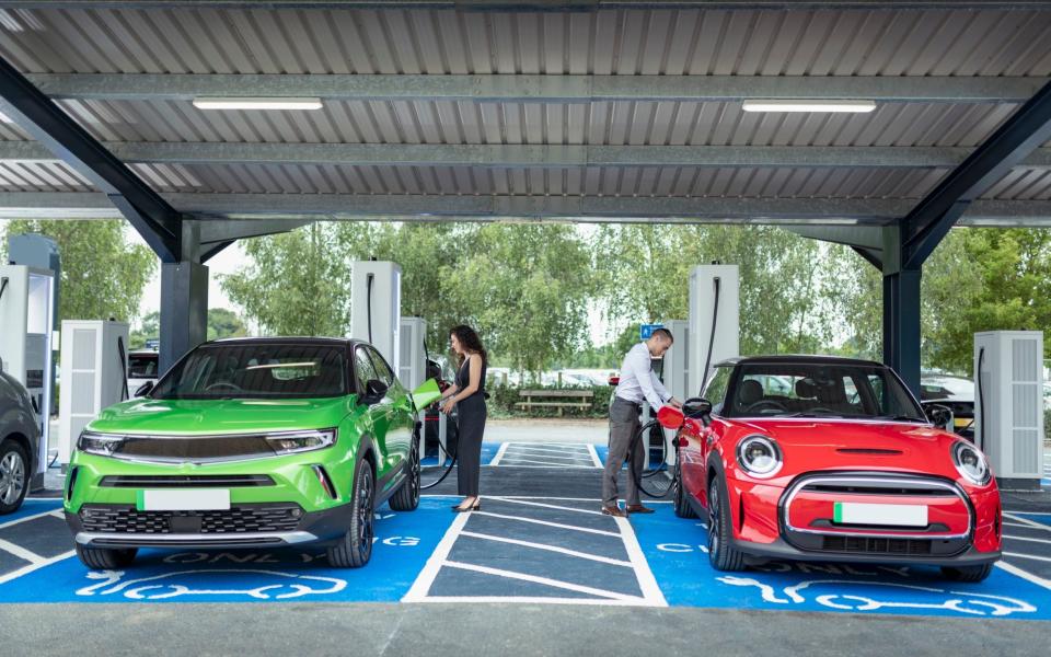 People charging their electric cars at charging station