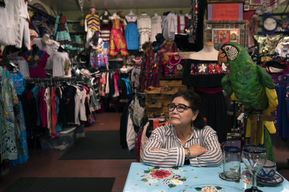 Martha Medina, owner of Olveritas souvenir shop on Olvera Street, sits for a photo in her shop in Los Angeles, Friday, June 4, 2021. During the darkest days of the coronavirus pandemic, Medina would return to her shuttered store on Los Angeles' oldest street to make sure everything was securely in place. Missing were the customers, employees and the constant pulse of traditional Mexican music such as cumbia, boleros and sones Jarochos, the Veracruz sound. "Those days I felt very sad," Medina said. "I had the feeling I would never open the shop again." (AP Photo/Jae C. Hong)