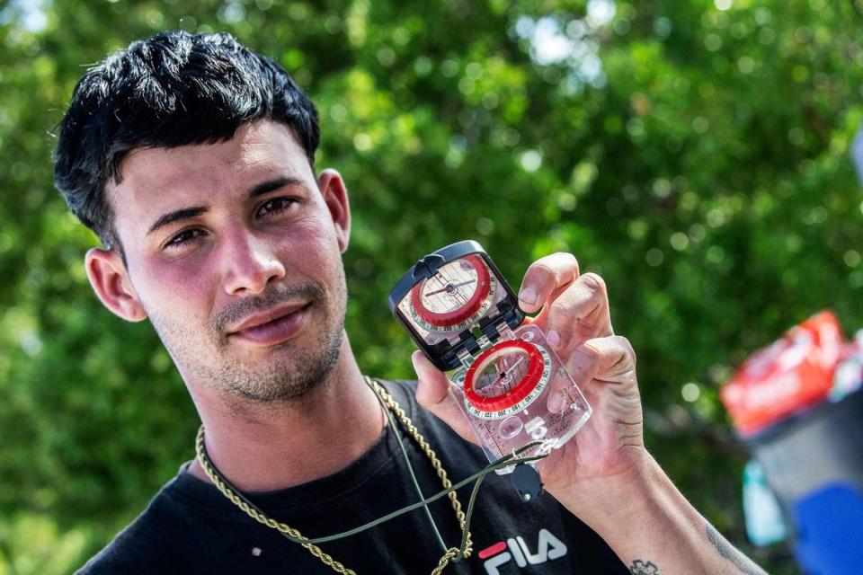 Jorge Yunier Cepa Sanchez, 22, displays the compass he used to lead one of two groups of Cuban migrants from Matanzas — one with 19 people, the other with 12 — that were standing in the sun on the side of U.S. 1 in the Middle Keys island of Duck Key Monday morning. By noon, they said they had been standing there waiting to be picked up by U.S. Border Patrol agents since arriving in two rustic vessels at 2:30 a.m. on Jan. 2, 2023.