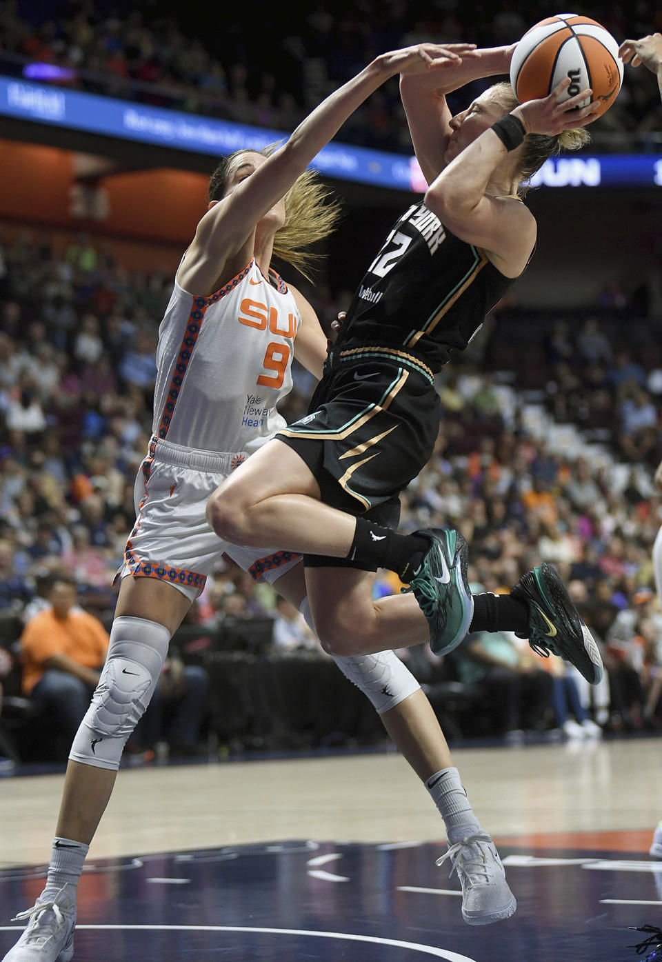 New York Liberty's Courtney Vandersloot (22) puts up a shot as she is guarded by Connecticut Sun's Rebecca Allen (9) during the first half of a WNBA basketball game, Tuesday, June 27, 2023 at Mohegan Sun Arena in Uncasville, Conn. (Sarah Gordon/The Day via AP)