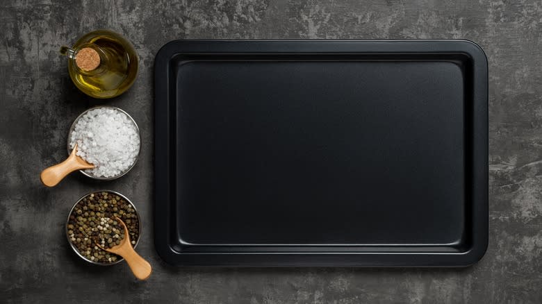 Baking sheet on a counter with olive oil, salt, and pepper